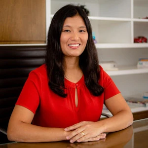 Doutora Gisela Tanno, médica otorrino, sorrindo para foto em seu moderno consultório.